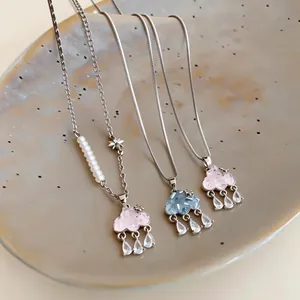 Elegant glass cloud necklaces with zircon waterdrop charms displayed on a ceramic dish