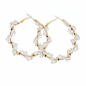 Elegant twisted gold hoop earrings adorned with sparkling clear faceted crystal beads