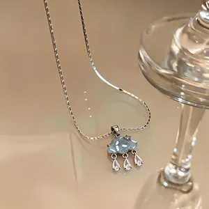 Detailed view of the blue cloud pendant and dangling zircon raindrops on a silver chain