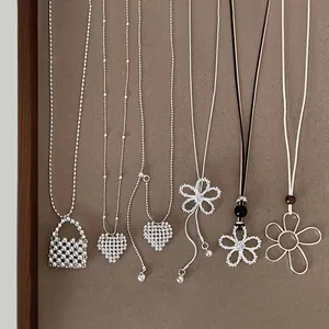 Variety of silver-toned necklaces featuring heart and hollow flower pendants