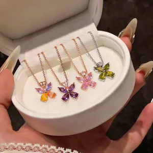Close-up of butterfly pendant necklaces with colored zircons in a white jewelry box.