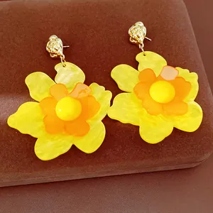 Detailed view of vibrant yellow resin flower earrings with tiered petal design.