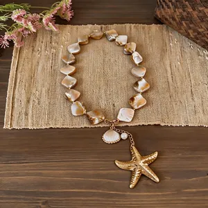 Beach vacation style necklace with irregular shell beads and golden starfish pendant detail