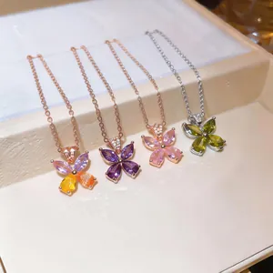 Close-up detail of sparkling zircon butterfly necklaces in rose gold and silver finish.