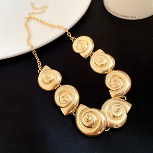 Detailed view of elegant gold metal conch shell pendants on a vintage style necklace