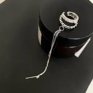 Detailed view of silver long tassel ear cuff with sparkling cubic zirconia accents.