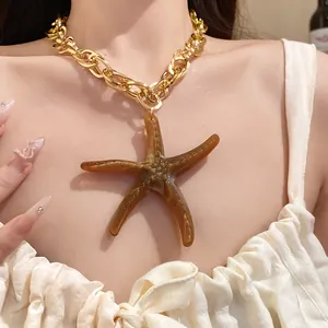 Close-up of a retro brown acrylic starfish pendant necklace on a chunky gold chain