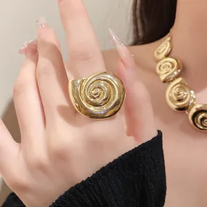 Close-up of a vintage gold metallic seashell ring on a model's finger for luxury style
