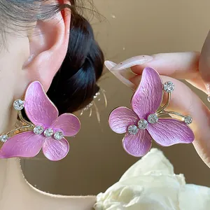 Close-up of elegant purple enamel butterfly earrings with sparkling zircon accents.