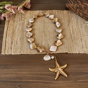 Detailed shot of a beach shell beaded necklace with a large golden starfish pendant.
