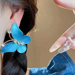 Macro view of a luxury blue enamel butterfly stud earring with sparkling zircon