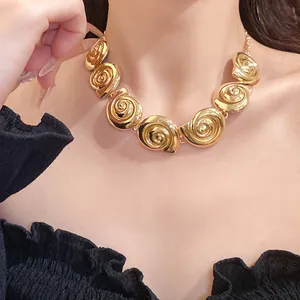 Macro view of vintage gold-tone metallic seashell spiral necklace on model's neck