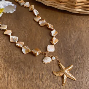 Close-up of irregular shell bead necklace with golden starfish and pearl pendants