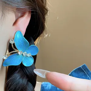 Detail showing elegant blue butterfly stud earring with sparkling zircon details
