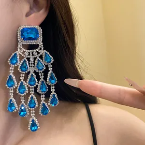 Detail shot of elegant blue teardrop tassel earrings with sparkling rhinestones