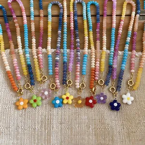 Close-up detail of colorful glass beaded necklaces featuring various flower pendants