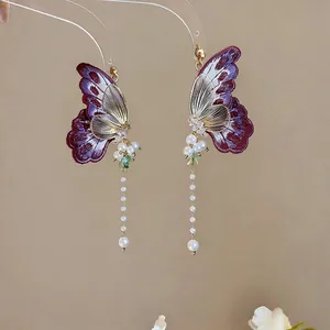Detail of butterfly embroidered earrings with long pearl tassels and crystals