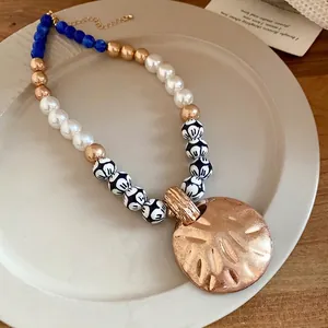 Vintage pearl and ceramic beaded necklace with large round textured gold pendant