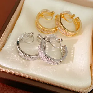 Close-up detail of gold and silver plated clip-on hoop earrings with CZ stones