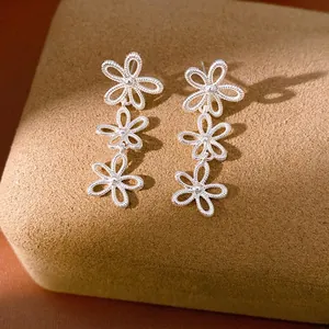 Elegant silver-toned hollow-out floral stud earrings with a minimalist drop design.