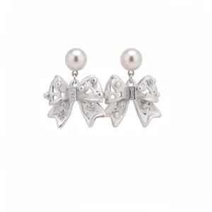 Silver-toned bow pendant earrings with elegant pearl studs and sparkling rhinestones