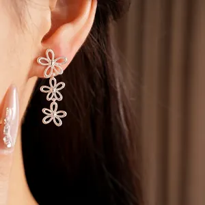 Elegant silver hollow flower drop earrings shown on model for a minimalist style.