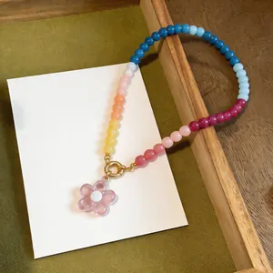 Close-up detail of a colorful dopamine glass beaded necklace with pink flower pendant