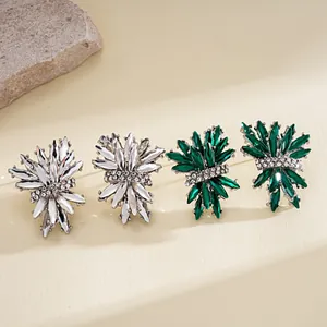 Detailed view of irregular firework stud earrings with silver and green crystals