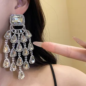 Detailed close-up of crystal water drop tassel earrings with square rhinestone accents