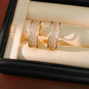 Close-up of elegant gold-plated hoop ear clips with sparkling baguette cubic zirconia