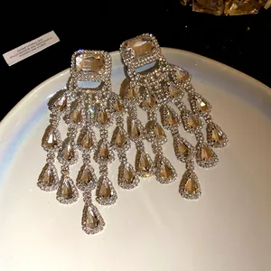 Detail view of sparkling silver tassel earrings with square and teardrop rhinestones