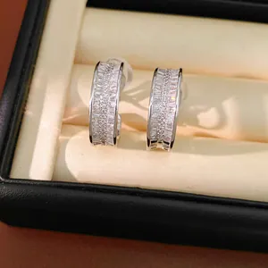 Close-up of silver-toned hoop clip-on earrings featuring baguette-cut crystals