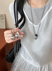 Detailed close-up of heart-shaped metal pendant necklaces with natural stone beads