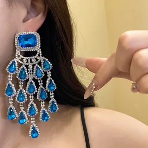 Detailed close-up of blue crystal water drop tassel earrings with silver needle.