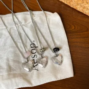 Close-up of three hammered heart necklaces with rose quartz, dalmatian jasper, and onyx beads.