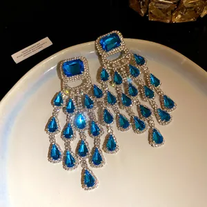 Detail shot of elegant blue teardrop tassel earrings with sparkling rhinestones