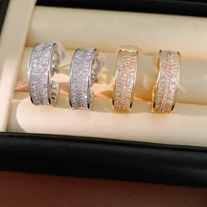 Close-up of gold and silver plated C-shaped ear clips with sparkling stones