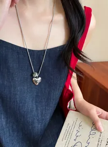 Detailed shot of a women's heart pendant necklace with a natural stone on a model.