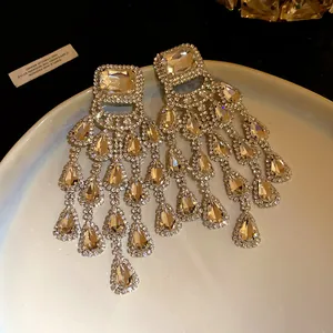 Detailed close-up of elegant silver needle earrings with rhinestone water-drop tassels