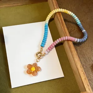 Vibrant dopamine style glass beaded necklace featuring a clear amber flower pendant