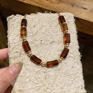 Close-up of vintage Maillard style acrylic barrel beads and gold accents necklace