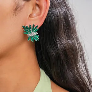 Detailed view of green firework stud earring with sparkling emerald and white stones