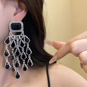Detail view of elegant black teardrop chandelier earrings with sparkling crystal tassels.