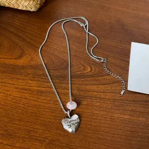Close-up of heart pendant necklace with pink natural stone and Eternal my love text