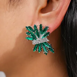 Close-up of green firework stud earrings with rhinestones on a model's ear