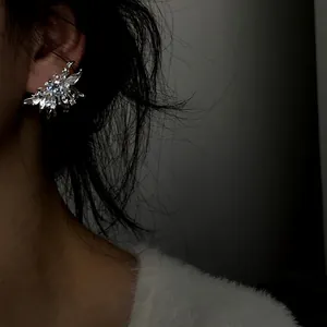 Elegant 3D flower zircon stud earrings shown worn on ear in a dark moody setting
