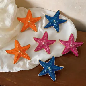 Detail view of colorful starfish earrings with drip oil finish and center pearl
