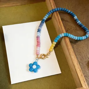 Close-up of vibrant dopamine style beaded necklace with blue flower pendant details