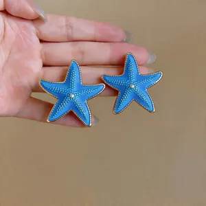 Blue enamel starfish stud earrings with gold-tone borders for beach vacations