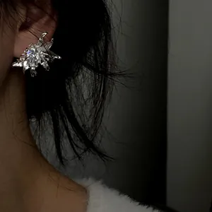 Detailed side view of a French luxury silver floral zircon stud earring worn on model's ear